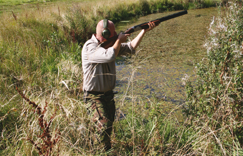 Wildfowler waiting for a clay practice target.